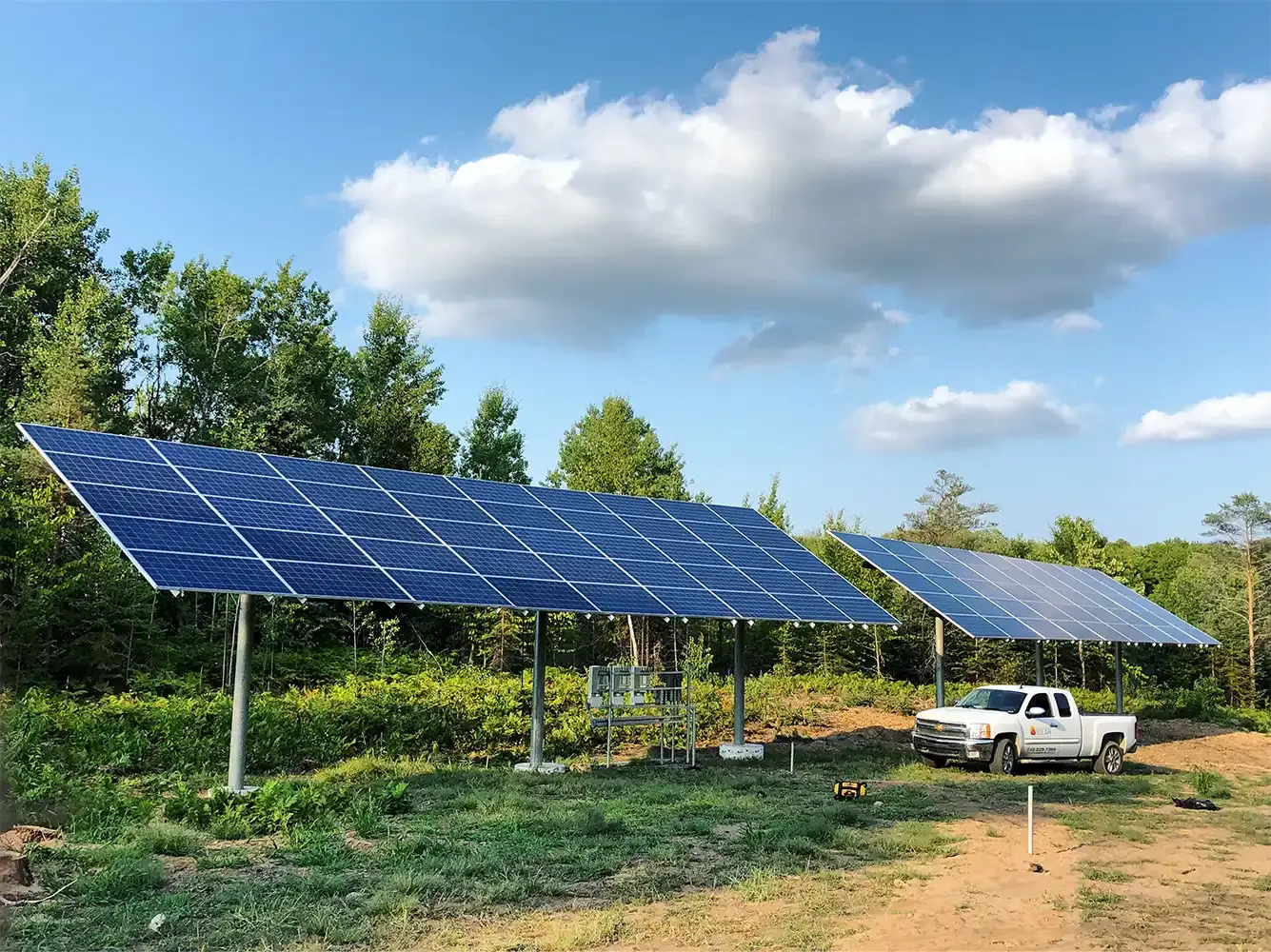 Large ground mounted solar panel by a work truck