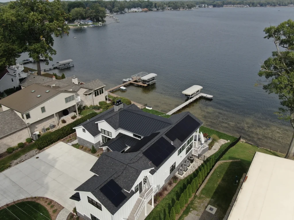 solar panels on a house with shingle and metal roof on a lake