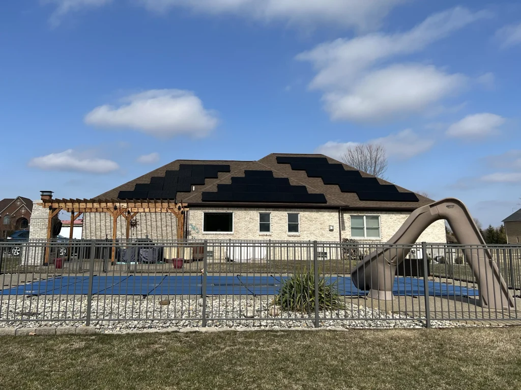 Solar panels on a roof of a house with a pool and slide